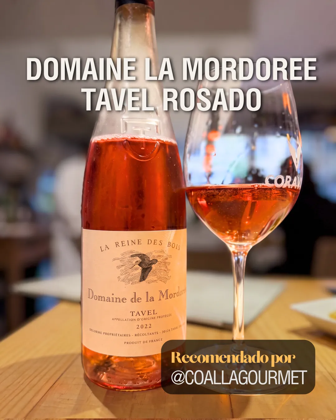 Botella y copa de Domaine la Mordoree Tavel Rosado 2022 servida en una mesa, recomendada por Coalla Gourmet